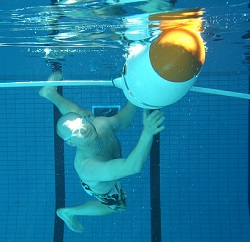 Diver in a pool with a robot.