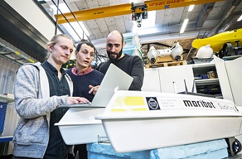 SMaRC team members in the lab working with a robot.