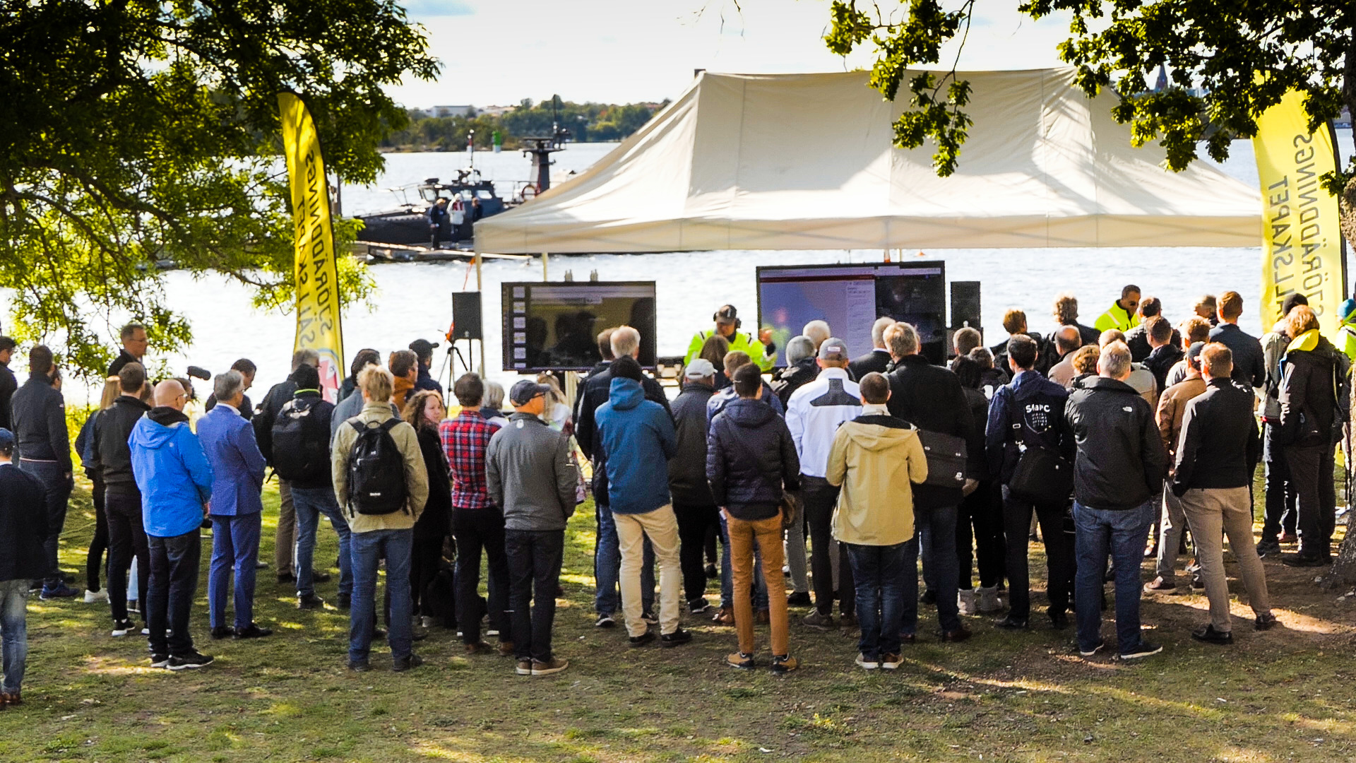 Audience listening to lecture outdoors.