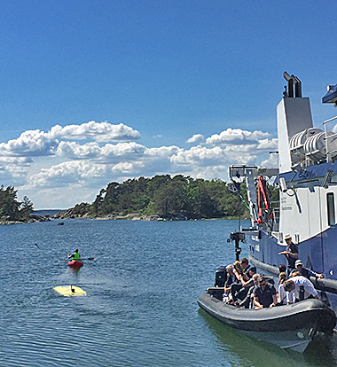 The LoLo robot outside in the bay with audience on a follower boat nearby.