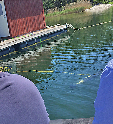 The SAM robot in sea water with audience on follower boat.