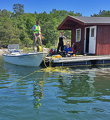 SMaRC team on the ground and the SAM robot in the sea.